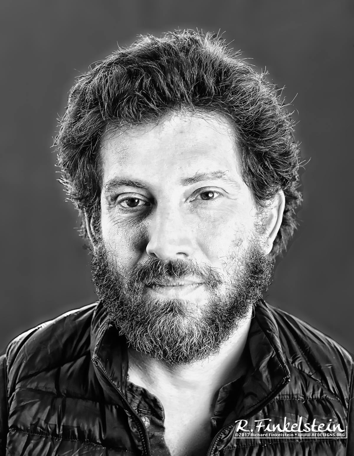 Image description: A professional headshot photo of Julian Boal. Julian is smiling and facing the camera and the photo is in grayscale.